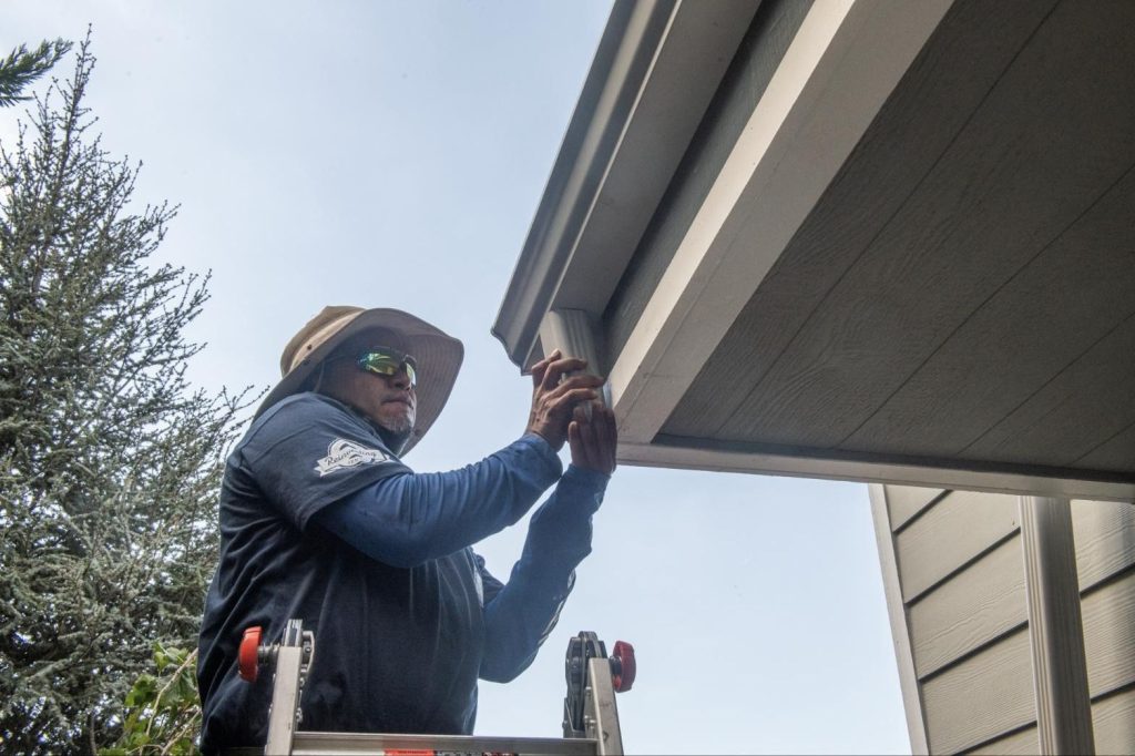 Fitting a downspout elbow at the eave